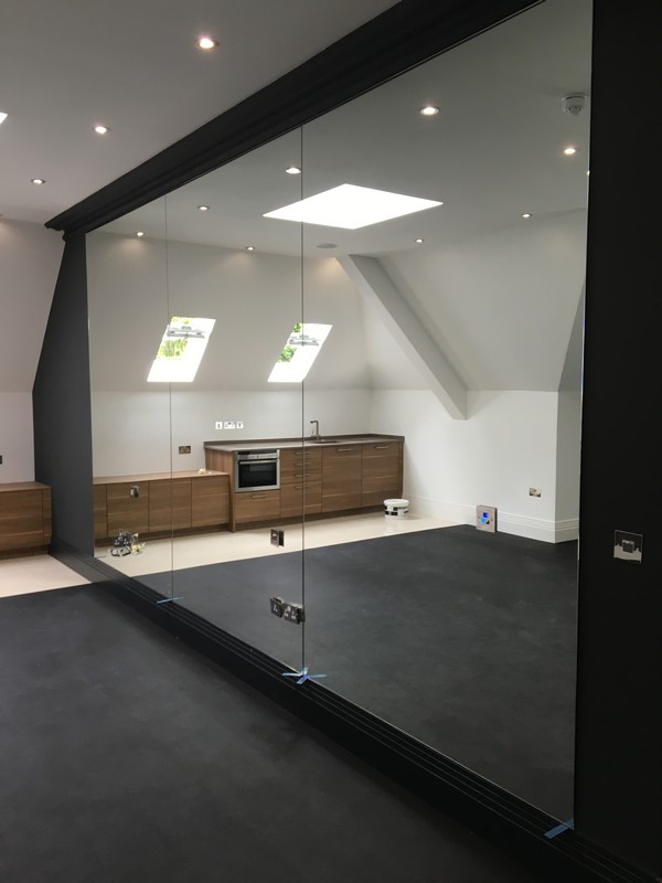 Frameless glass partition in loft conversion by Brockley glaziers